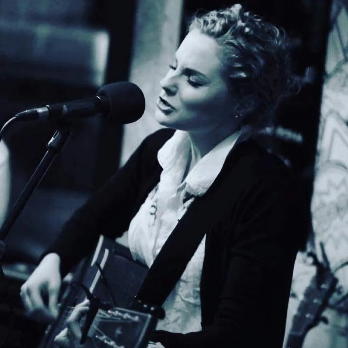 Black and white portrait of Rachael Jackson singing into a microphone