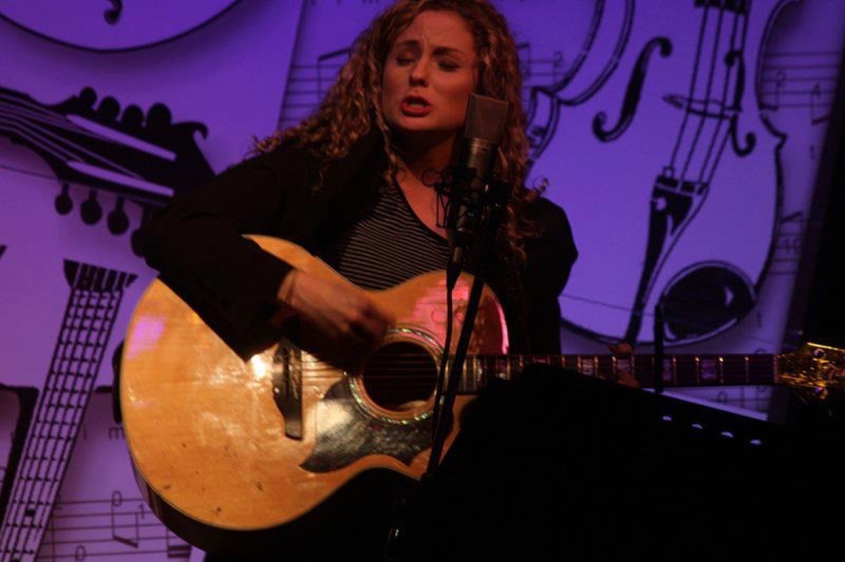 Rachael Jackson performing live with an acoustic guitar